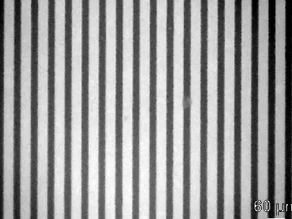 A privacy filter under a microscope, its slats showing as dark vertical stripes